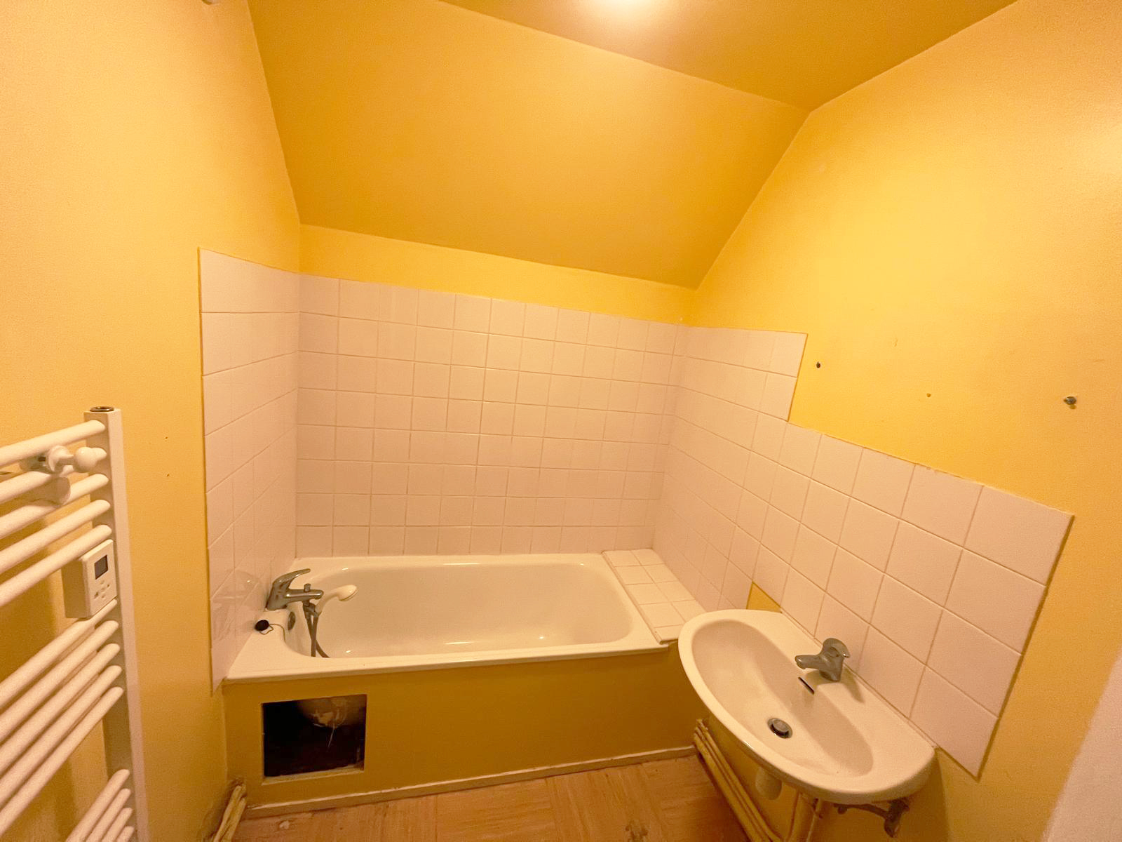 Avant travaux : baignoire à enjamber et lavabo sur faïence blanche
