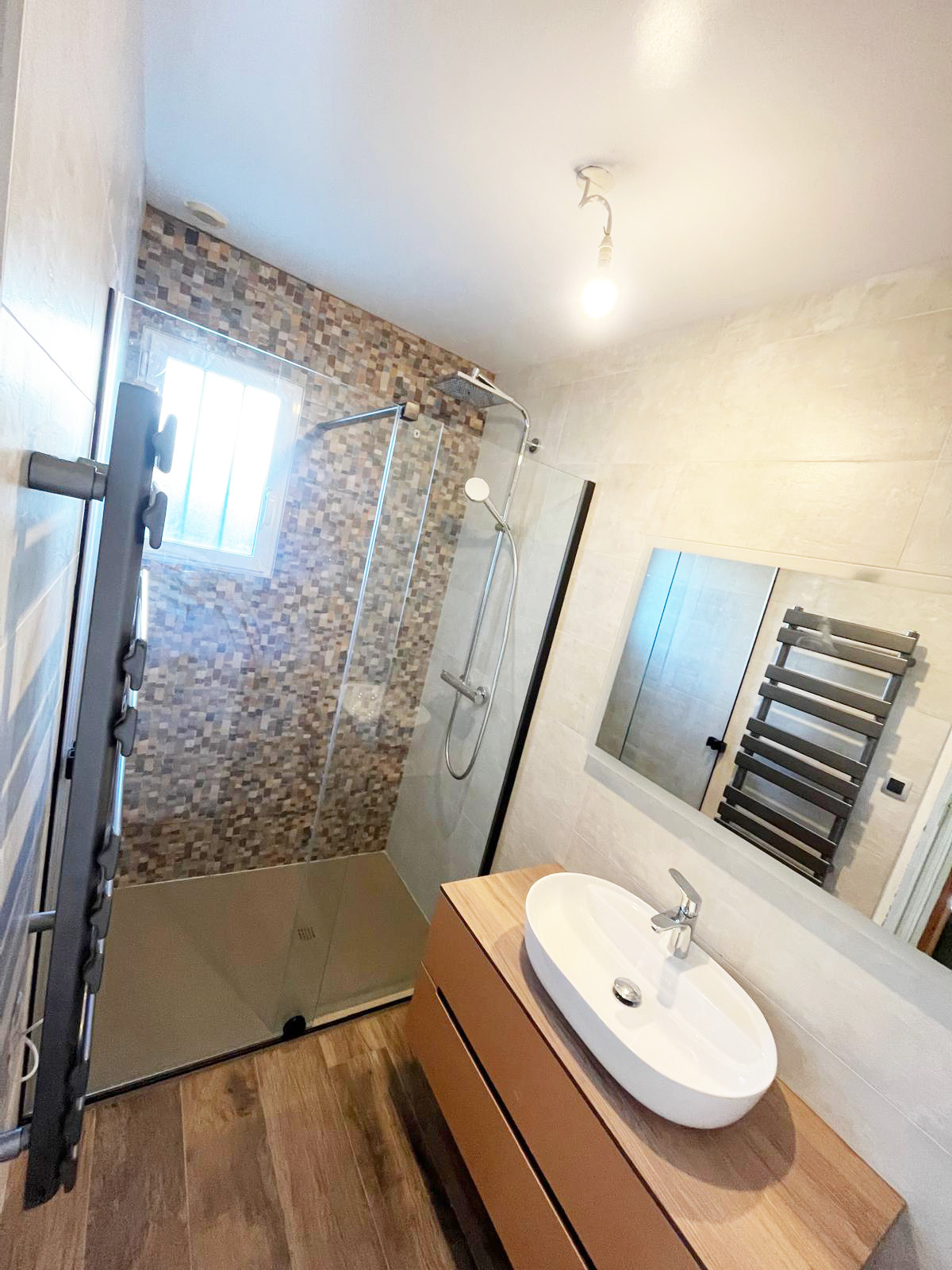 Salle de bains avec douche mosaïque, vasque posée et sèche-serviettes anthracite