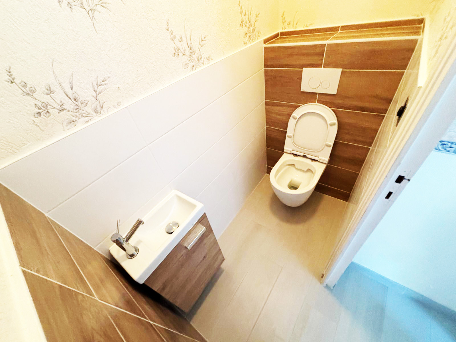 WC suspendu sur bâti-support avec lave-mains et carrelage imitation bois à Lorient